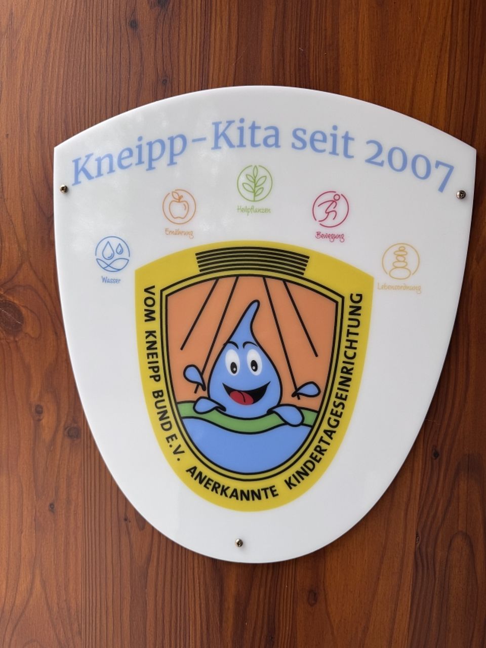 Plakette „Kneipp-Kita seit 2007“ mit dem offiziellen Anerkennungs-Siegel des Kneipp-Bund e.V..